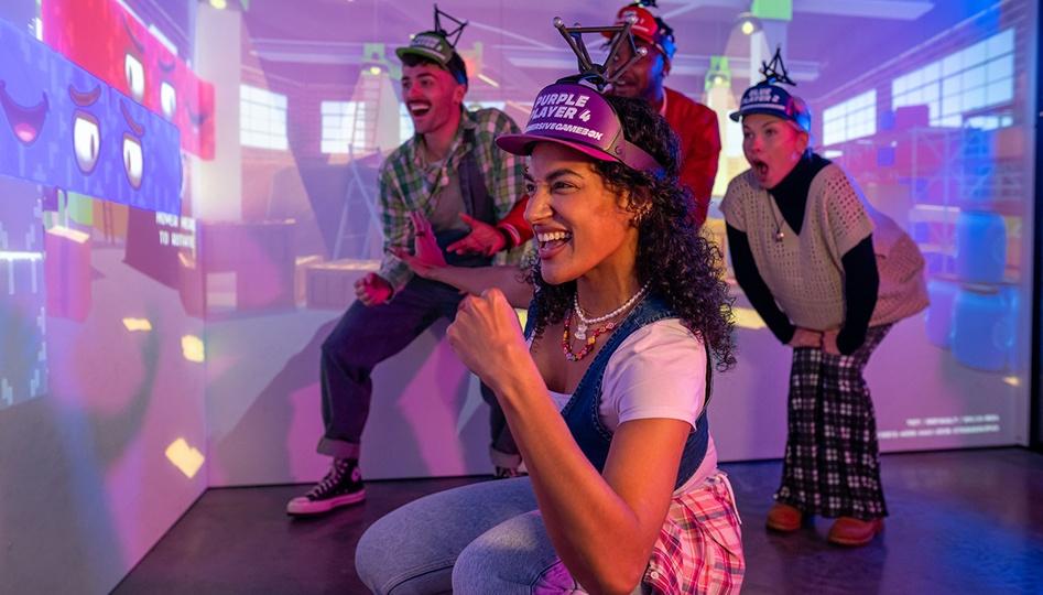 Excited people wearing game headsets in a colourful immersive gaming room