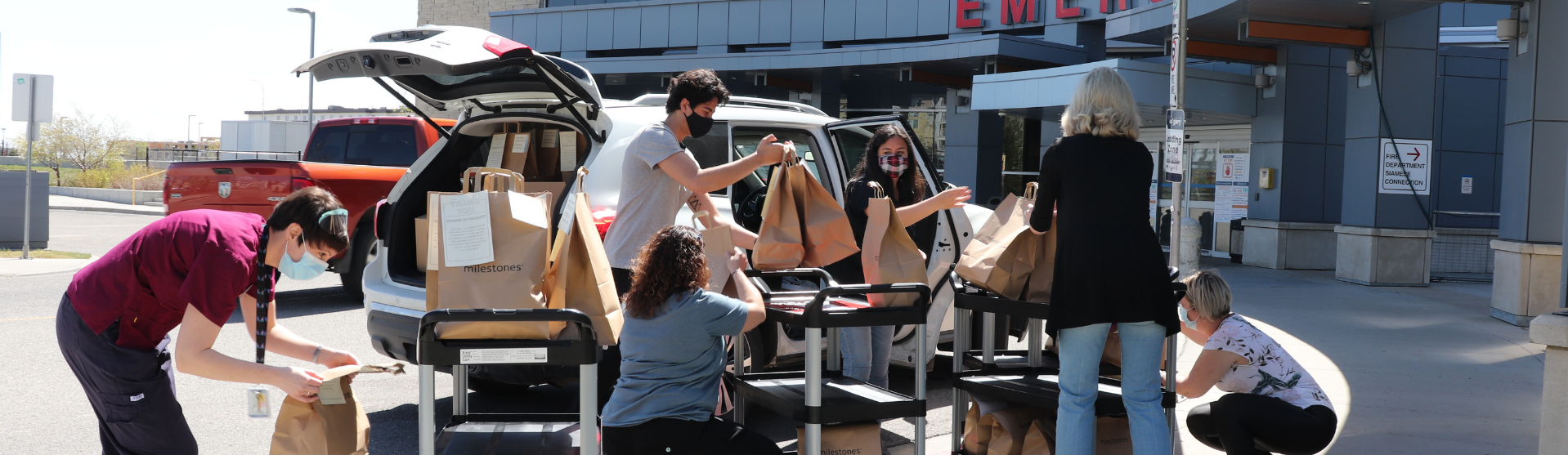 Several people loading donations in front of a hospital