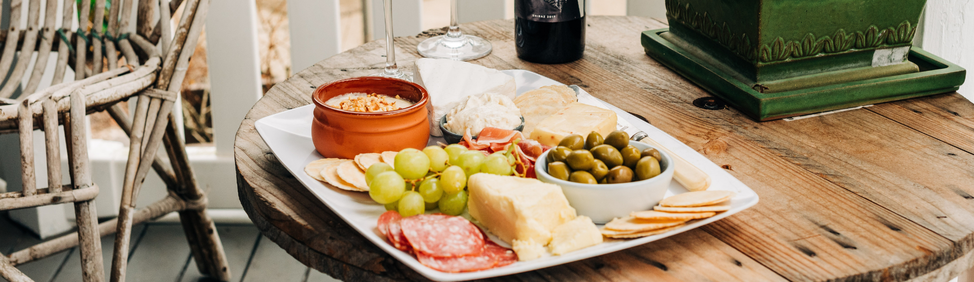 Plate of charcuterie with wine glasses